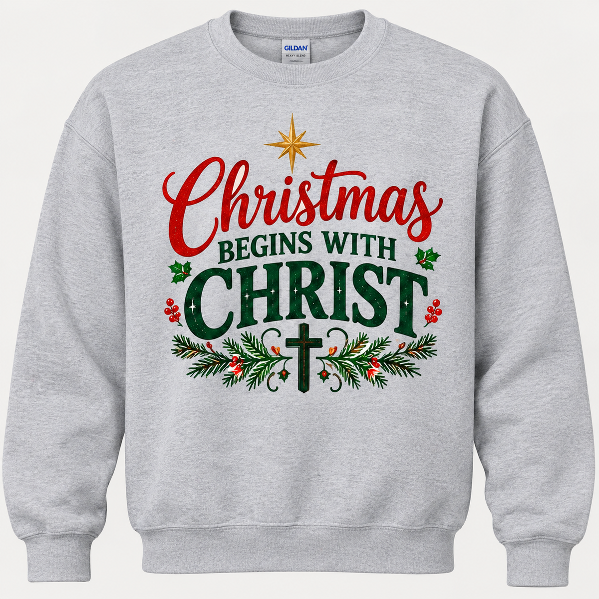 Light heather gray crewneck sweatshirt featuring a festive red and green "Christmas Begins with Christ" graphic print with holiday greenery